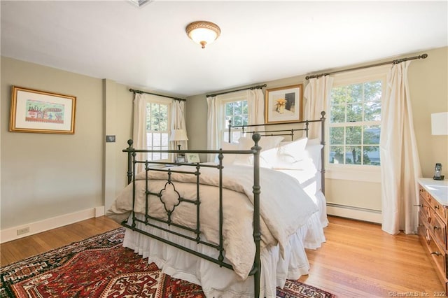 521 State St, Guilford, CT 06437 - bedroom with light wood finished floors, a baseboard heating unit, and baseboards