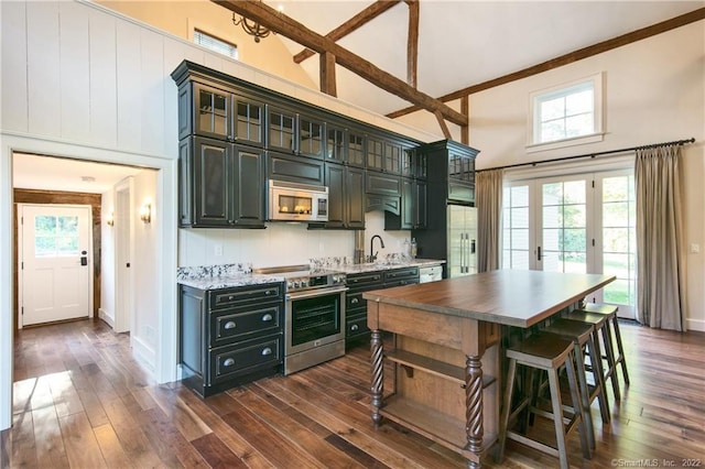 521 State St, Guilford, CT 06437 - kitchen featuring appliances with stainless steel finishes, high vaulted ceiling, a sink, a center island, and dark wood finished floors