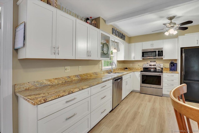 20 Thayer Road Ext, Haddam, CT 06441 - kitchen featuring stainless steel appliances, a sink, light wood finished floors, white cabinetry, and beamed ceiling