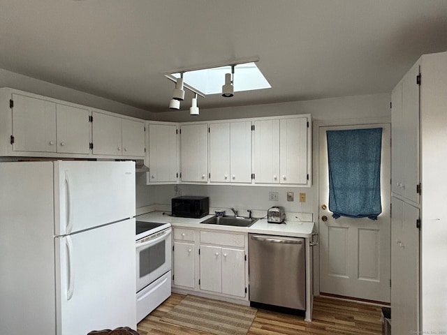 24 Saint Johns Pl Apt 6, New Canaan, CT 06840 - kitchen featuring white appliances, a sink, a skylight, light wood-style flooring, and light countertops