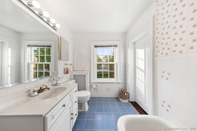 1050 King St, Greenwich, CT 06831 - bathroom with tile walls, tile patterned flooring, toilet, wainscoting, and vanity
