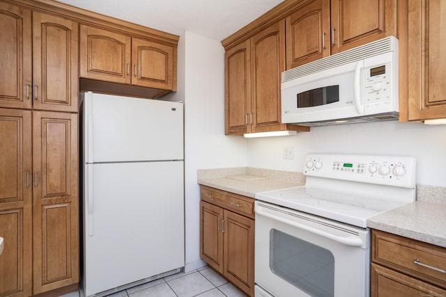 592 Mountain Rd Unit A, West Hartford, CT 06117 - kitchen with white appliances, brown cabinetry, and light tile patterned flooring