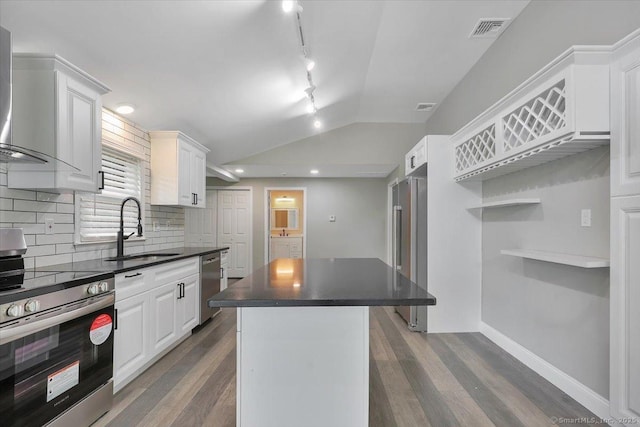1813 Peck Ln, Cheshire, CT 06410 - kitchen with stainless steel appliances, a sink, dark countertops, a center island, and dark wood-type flooring