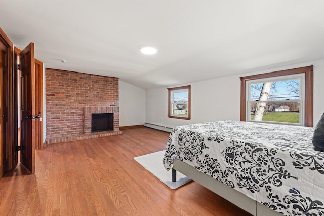 689 S Meriden Rd, Cheshire, CT 06410 - bedroom featuring a baseboard radiator, wood finished floors, multiple windows, a fireplace, and lofted ceiling