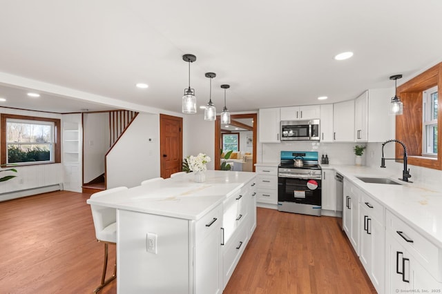 689 S Meriden Rd, Cheshire, CT 06410 - kitchen with stainless steel appliances, a sink, light wood-type flooring, a kitchen bar, and recessed lighting