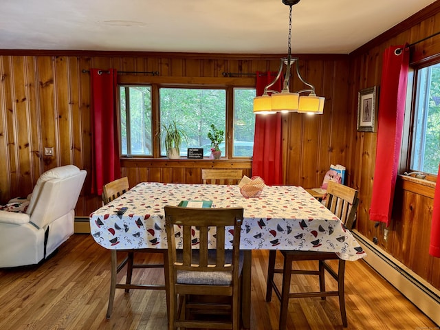 492 Providence New London Tpke, North Stonington, CT 06359 - dining area featuring a baseboard radiator, wood finished floors, and wood walls