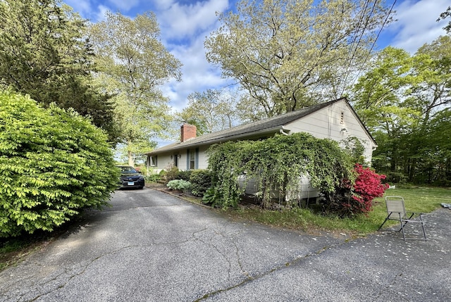 492 Providence New London Tpke, North Stonington, CT 06359 - view of property exterior with a chimney and asphalt driveway