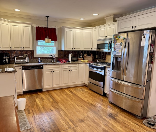 492 Providence New London Tpke, North Stonington, CT 06359 - kitchen featuring stainless steel appliances, a sink, white cabinets, light wood-style floors, and ornamental molding
