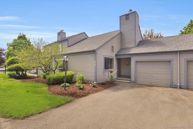 547 Pilgrim Hbr Unit 547, Wallingford, CT 06492 - view of front of home featuring a chimney, a garage, roof with shingles, and driveway
