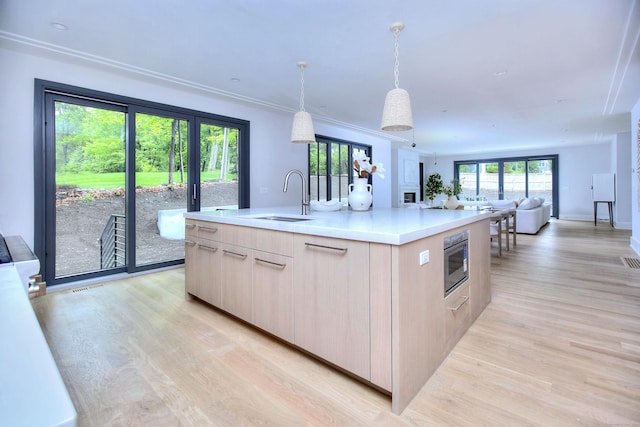 158 Compo Rd N, Westport, CT 06880 - kitchen featuring a sink, modern cabinets, light wood-style floors, a kitchen island with sink, and light countertops