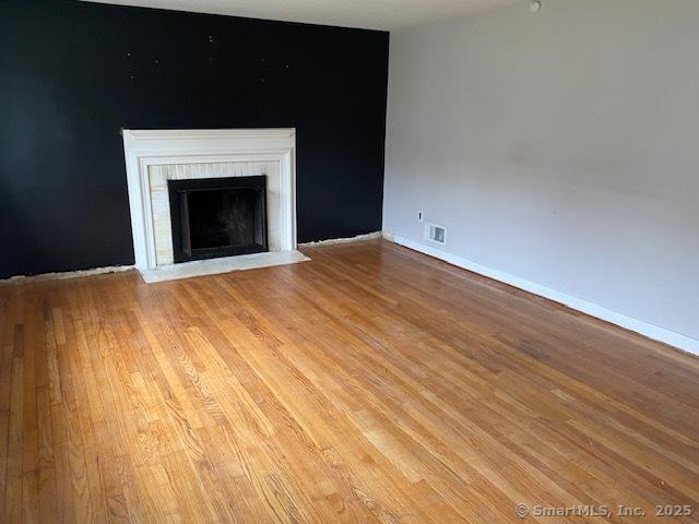 147 Chester St, East Hartford, CT 06108 - unfurnished living room with light wood-style flooring, a fireplace, and baseboards
