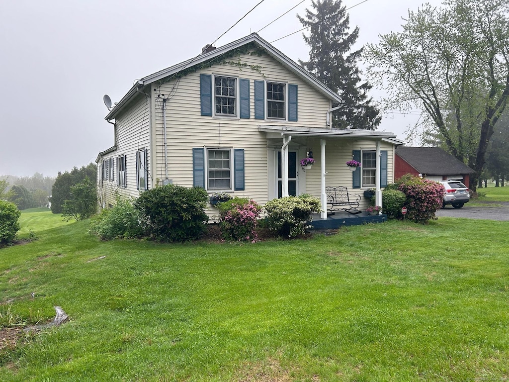 view of front of home with a porch and a front lawn