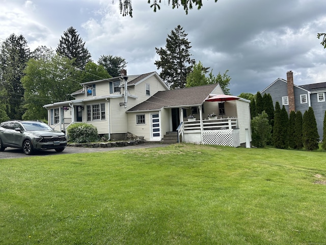 2060 Perkins St, Bristol, CT 06010 - traditional-style home featuring a front yard, a chimney, and covered porch