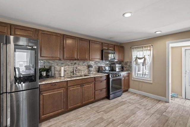 24 High St, West Haven, CT 06516 - kitchen with appliances with stainless steel finishes, a sink, tasteful backsplash, baseboards, and light wood-type flooring