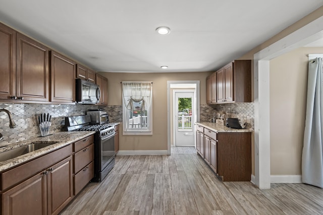 24 High St, West Haven, CT 06516 - kitchen with black range with gas stovetop, stainless steel microwave, a sink, light wood-type flooring, and baseboards