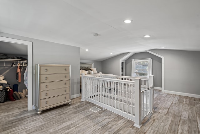 24 High St, West Haven, CT 06516 - bedroom with wood finished floors, a closet, vaulted ceiling, baseboards, and a walk in closet