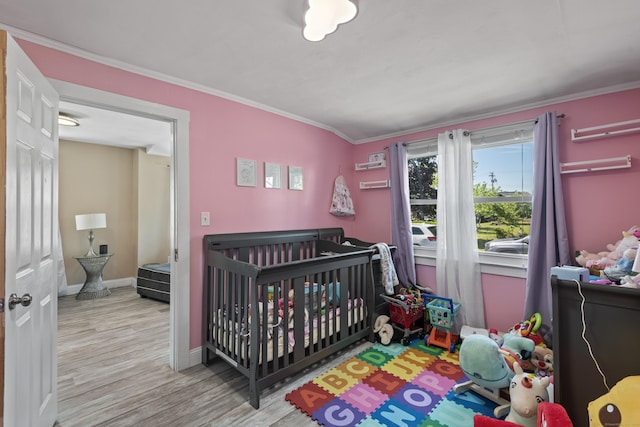 24 High St, West Haven, CT 06516 - bedroom featuring wood finished floors, crown molding, baseboards, and a crib