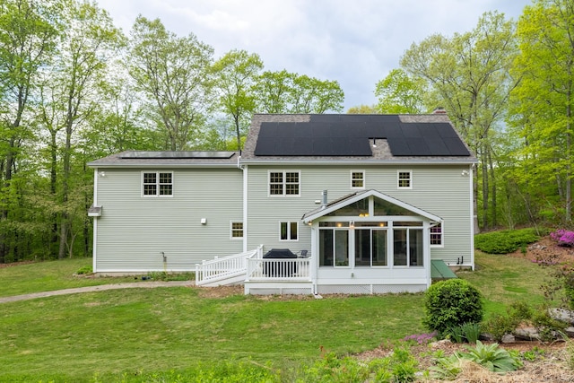 67 Blue Heron Dr, East Hampton, CT 06424 - back of property featuring a sunroom, a yard, roof mounted solar panels, and a deck
