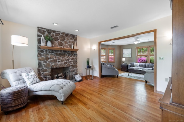 67 Blue Heron Dr, East Hampton, CT 06424 - living area featuring light wood-style flooring, a stone fireplace, a ceiling fan, and baseboards