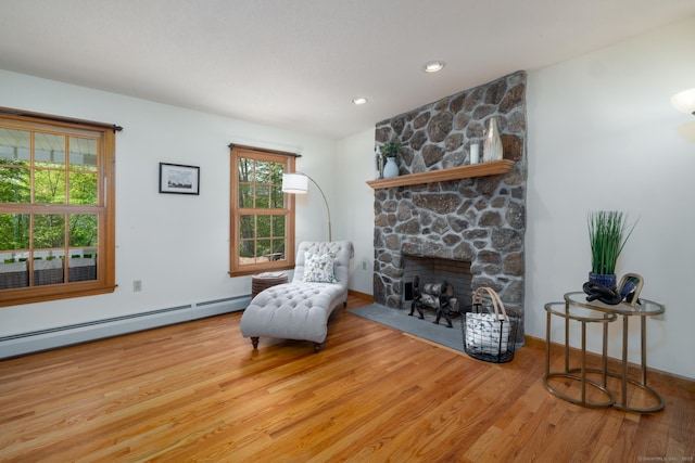 67 Blue Heron Dr, East Hampton, CT 06424 - sitting room with wood finished floors, a baseboard radiator, and a stone fireplace