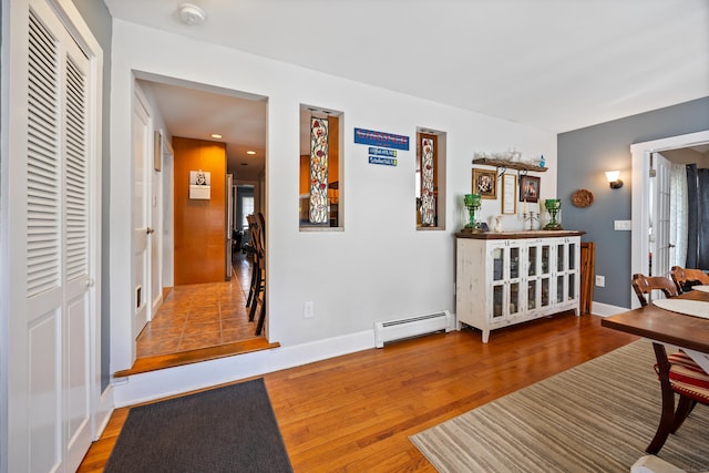 entryway with baseboard heating, wood finished floors, baseboards, and recessed lighting