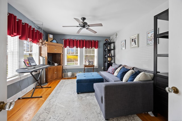 living area featuring plenty of natural light, a ceiling fan, and light wood finished floors