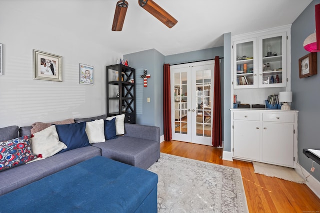 living area featuring french doors, light wood finished floors, and a ceiling fan