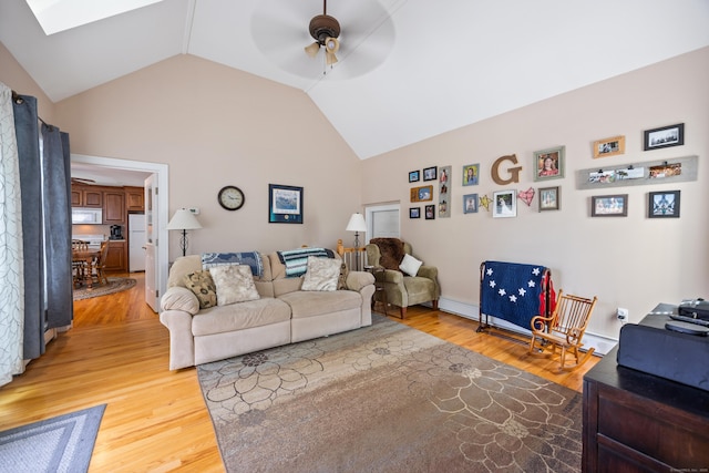 living room with ceiling fan, light wood finished floors, and high vaulted ceiling