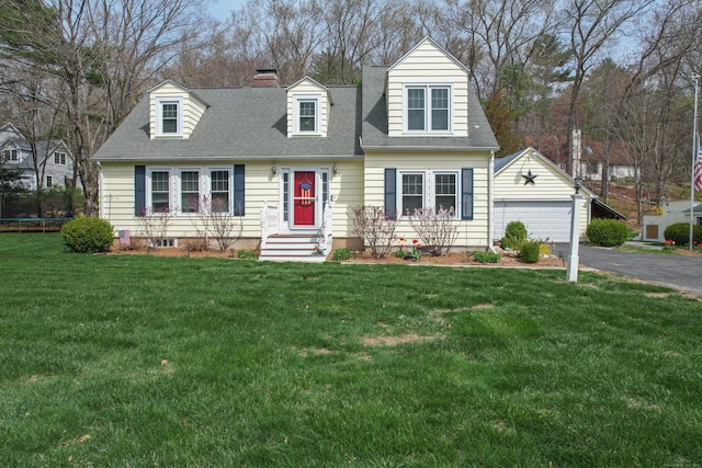 cape cod house with an outbuilding, a detached garage, a front yard, a shingled roof, and a chimney