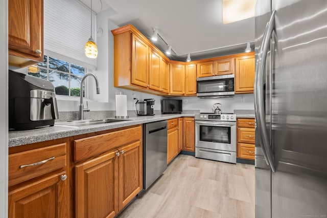 8 Pasco Dr Unit E, East Windsor, CT 06088 - kitchen with appliances with stainless steel finishes, a sink, track lighting, brown cabinetry, and light wood finished floors