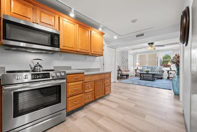 8 Pasco Dr Unit E, East Windsor, CT 06088 - kitchen featuring appliances with stainless steel finishes, track lighting, ceiling fan, light wood-style floors, and brown cabinets