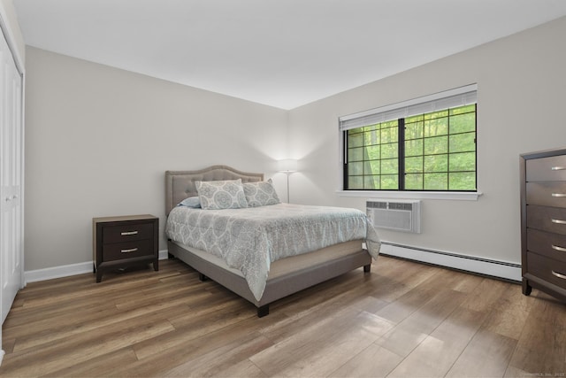 442 Swanson Cres Unit 442, Milford, CT 06461 - bedroom with a baseboard heating unit, an AC wall unit, wood finished floors, and baseboards