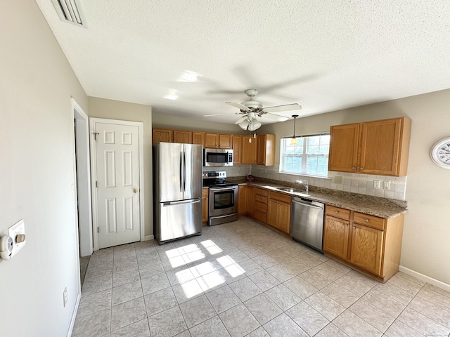 26 John George Dr, Meriden, CT 06450 - kitchen featuring stainless steel appliances, backsplash, light tile patterned floors, a sink, and a textured ceiling