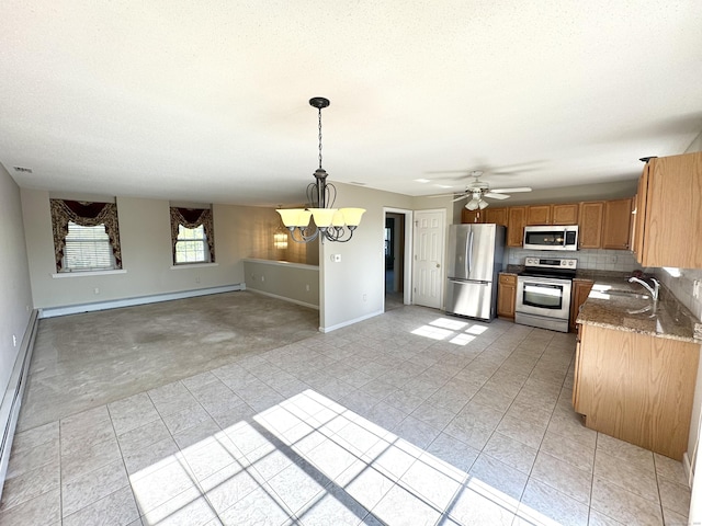 26 John George Dr, Meriden, CT 06450 - kitchen featuring appliances with stainless steel finishes, a chandelier, light tile patterned floors, light colored carpet, and brown cabinetry