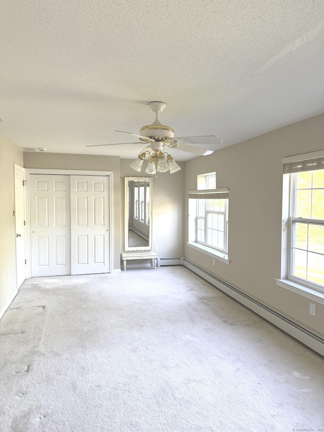 26 John George Dr, Meriden, CT 06450 - unfurnished bedroom with a textured ceiling, a closet, carpet floors, a baseboard radiator, and ceiling fan