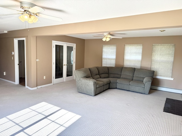 26 John George Dr, Meriden, CT 06450 - living room with light colored carpet, a ceiling fan, french doors, a baseboard radiator, and baseboards