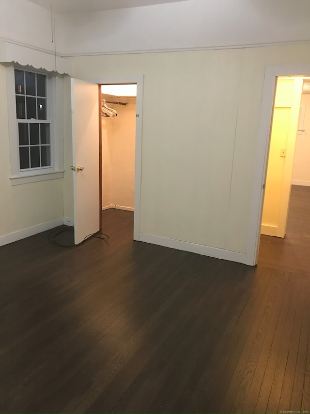 61 Williams St, Norwich, CT 06360 - unfurnished bedroom with dark wood finished floors, baseboards, and a spacious closet