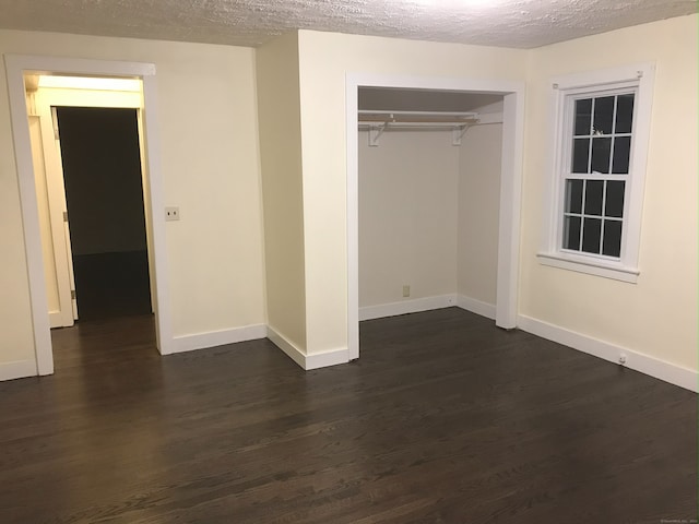 61 Williams St, Norwich, CT 06360 - unfurnished bedroom with dark wood-type flooring, baseboards, a textured ceiling, and a closet