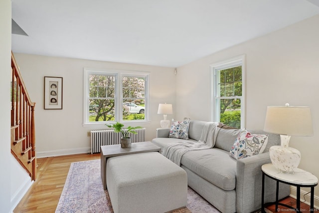 8 Bailey St, Trumbull, CT 06611 - living room featuring radiator, healthy amount of natural light, stairway, and light wood-style floors