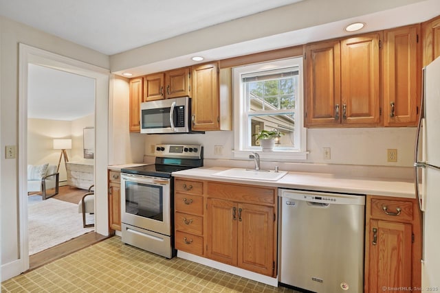 8 Bailey St, Trumbull, CT 06611 - kitchen with appliances with stainless steel finishes, light countertops, light flooring, brown cabinetry, and recessed lighting