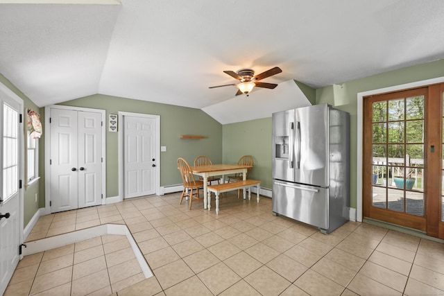 kitchen with stainless steel fridge, lofted ceiling, light tile patterned floors, ceiling fan, and baseboard heating
