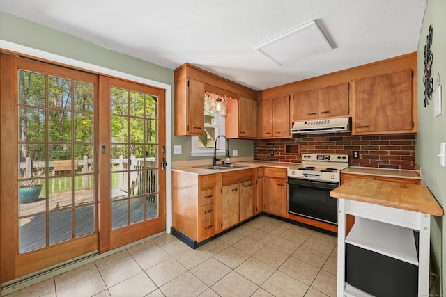 kitchen with electric range, a sink, range hood, light countertops, and decorative backsplash