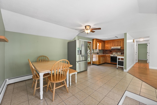 dining room with light tile patterned flooring, a ceiling fan, baseboards, and lofted ceiling