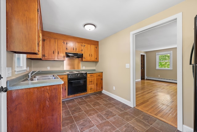 kitchen featuring electric range, baseboard heating, under cabinet range hood, a sink, and brown cabinetry