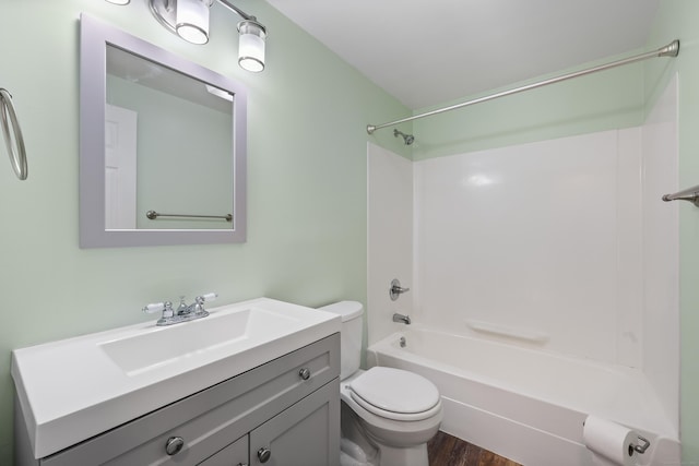 bathroom with toilet, wood finished floors, vanity, and shower / tub combination