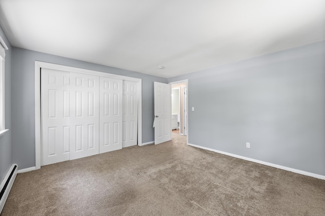 unfurnished bedroom with a baseboard heating unit, carpet floors, and baseboards