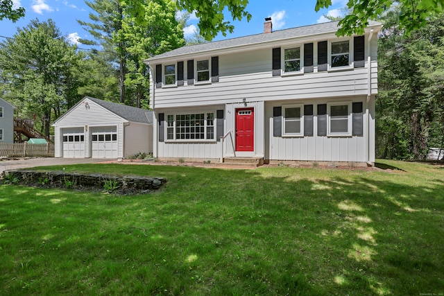 colonial-style house with a detached garage, an outbuilding, entry steps, and a chimney