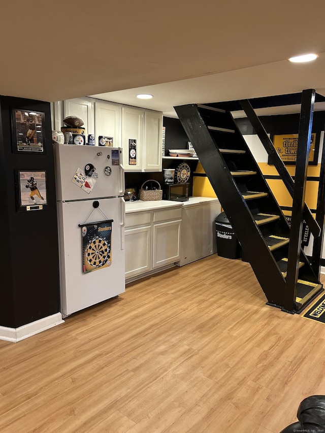 kitchen featuring freestanding refrigerator, light wood-style floors, white cabinetry, light countertops, and recessed lighting