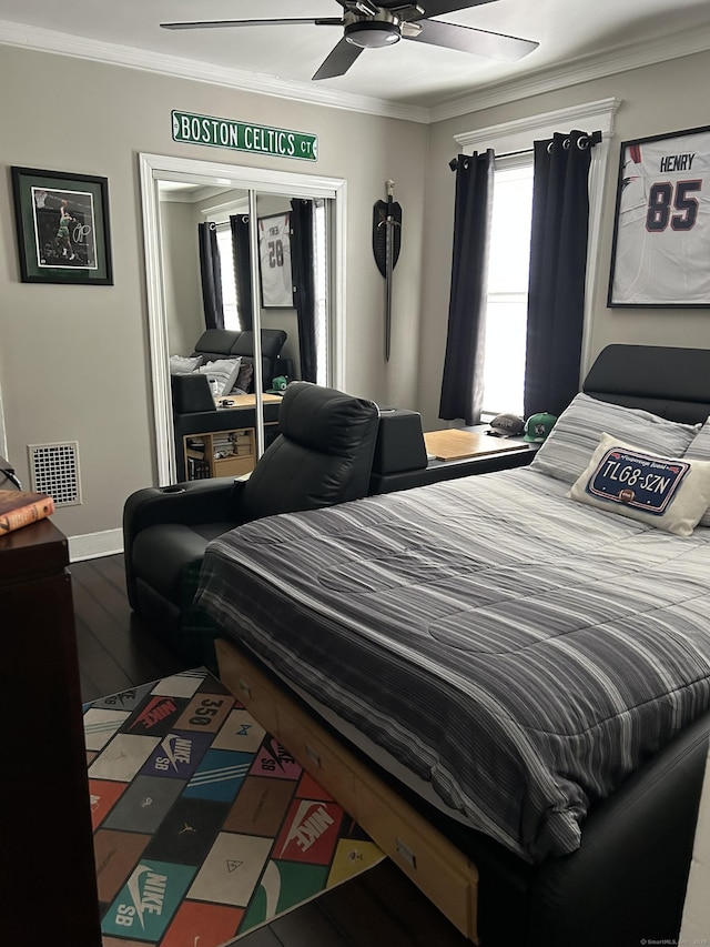 bedroom featuring crown molding, wood finished floors, a ceiling fan, and baseboards