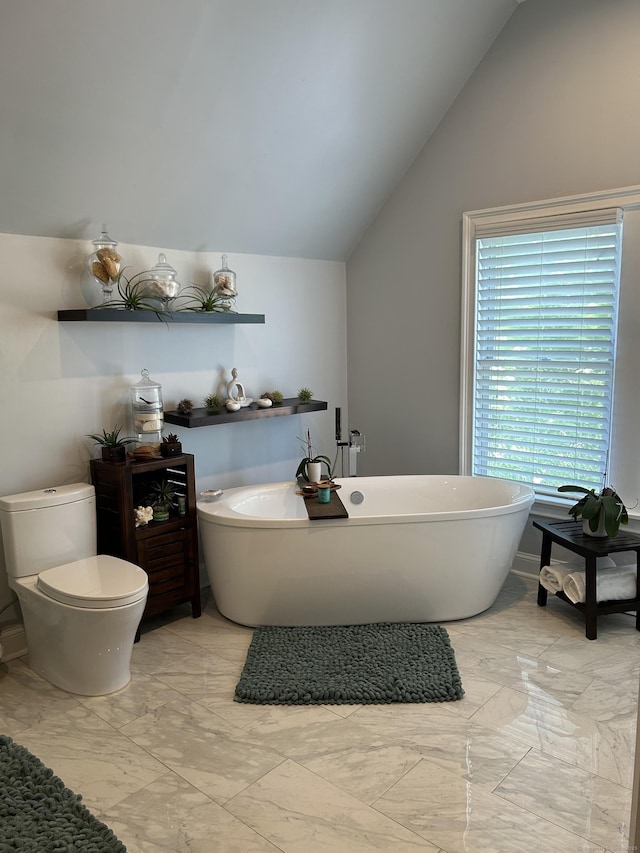 full bathroom featuring marble look tiles, vaulted ceiling, toilet, and a soaking tub